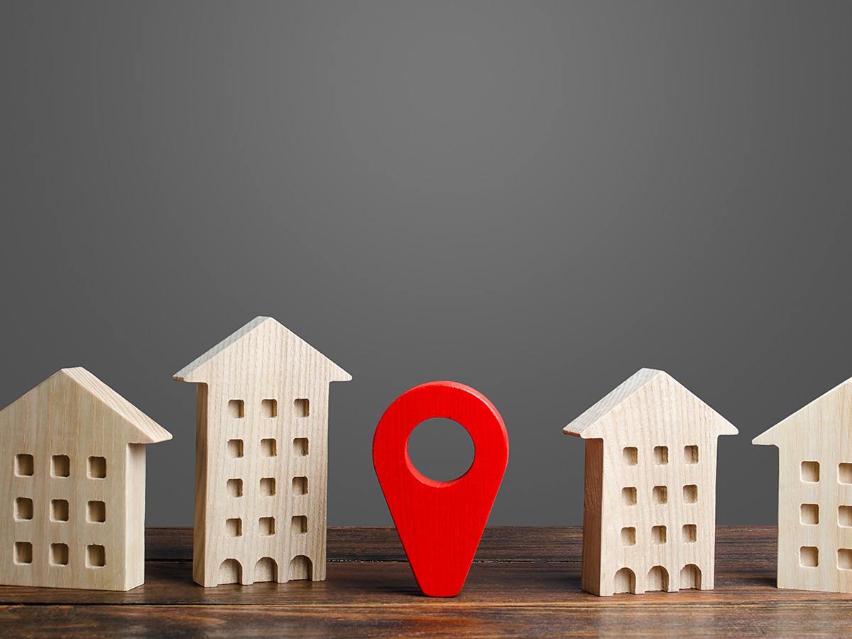 Figuras de madera representando que la ubicación es esencial al comprar departamento